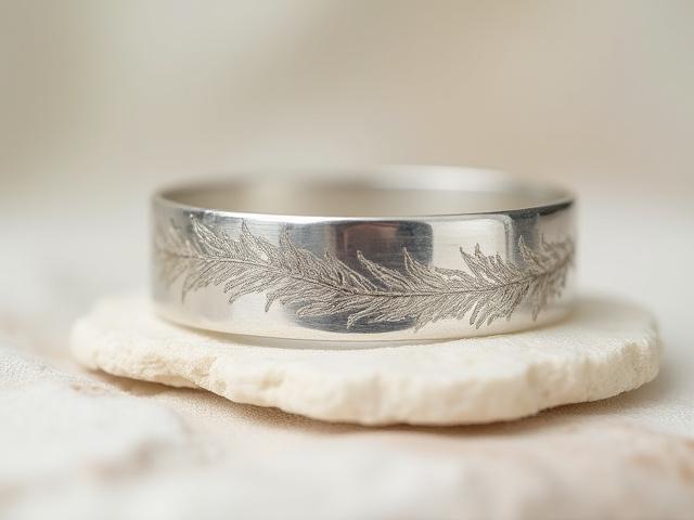 Wide sterling silver cuff bracelet with delicate botanical imprints, nature-inspired