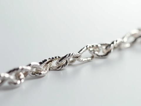 Extreme macro view of sterling silver chain links, showing intricate craftsmanship.