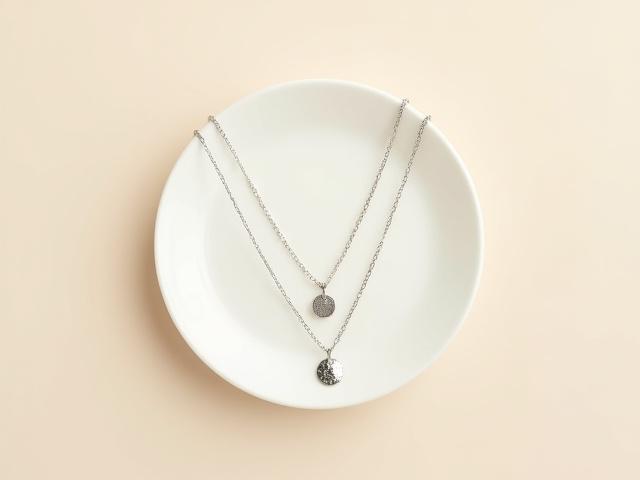 Set of two dainty silver layering necklaces with natural textures.