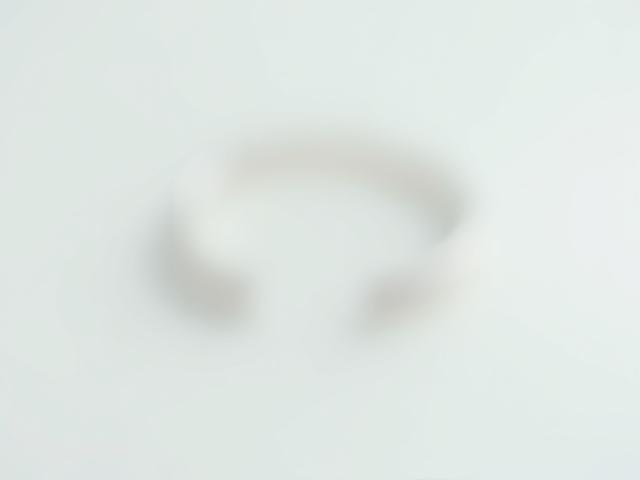 A polished, classic simple sterling silver band ring on a neutral background.